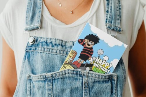 Personalised Dennis menace cannon birthday card template with 'Happy Birthday' text and space for a name, ideal for custom celebrations.