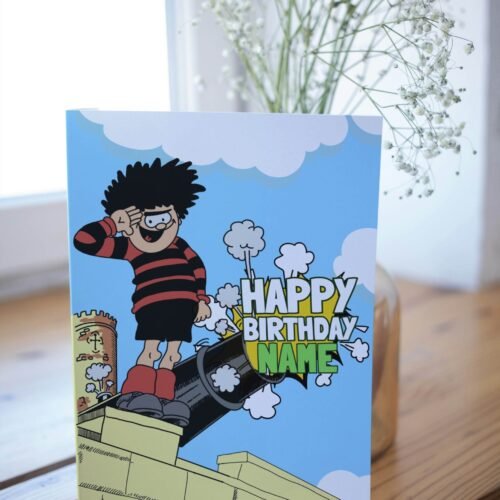 Personalised Dennis menace cannon birthday card template with 'Happy Birthday' text and space for a name, ideal for custom celebrations.