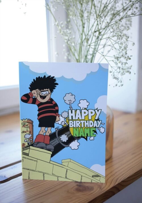 Personalised Dennis menace cannon birthday card template with 'Happy Birthday' text and space for a name, ideal for custom celebrations.
