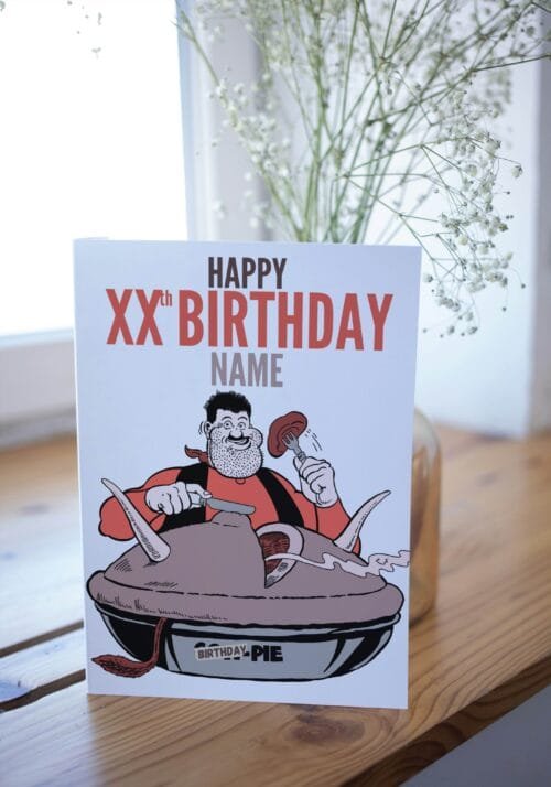 Desperate Dan birthday card featuring 'Happy Xth Birthday' text with space for name and birthday pie illustration displayed on table