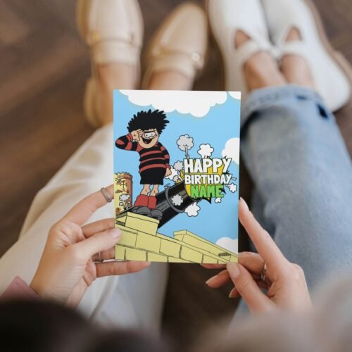 Personalised Dennis menace cannon birthday card template with 'Happy Birthday' text and space for a name, ideal for custom celebrations.