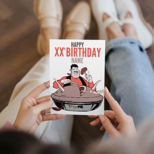 Person holding Desperate Dan birthday card featuring 'Happy Xth Birthday' text with space for name and birthday pie illustration