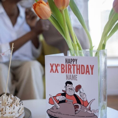 Person holding Desperate Dan birthday card featuring 'Happy Xth Birthday' text with space for name and birthday pie illustration