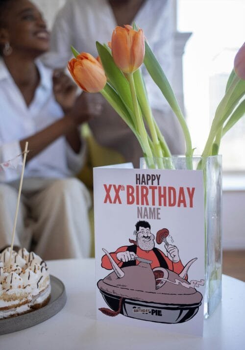 Person holding Desperate Dan birthday card featuring 'Happy Xth Birthday' text with space for name and birthday pie illustration