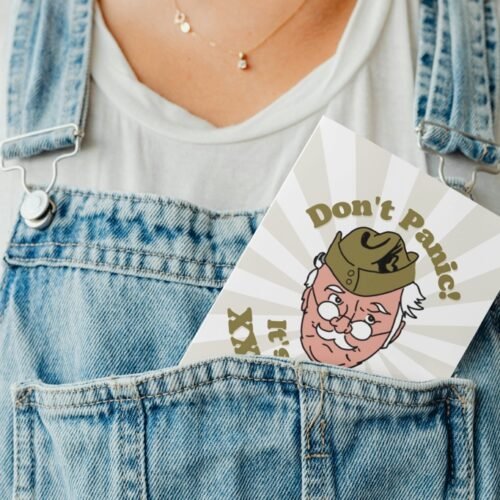 Don’t Panic birthday card peeking out of a denim dungaree pocket for a playful display shot
