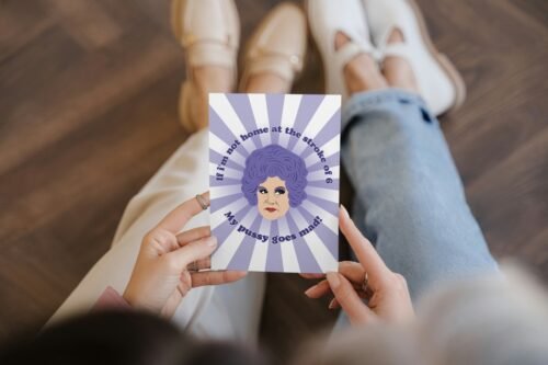 Person holding a Mrs Slocombe Pussy Card featuring her iconic quote and retro artwork