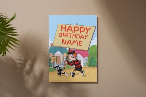 Cartoon birthday card with custom name on front, placed flat on wood