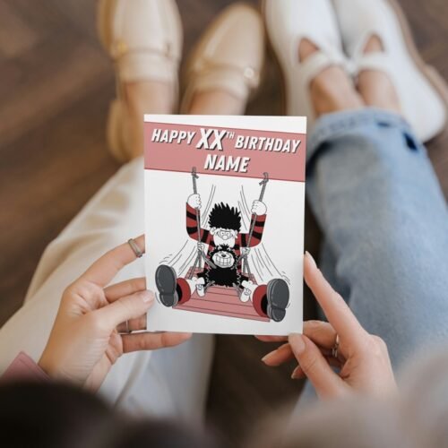 Dennis the Menace personalised birthday card with name and age on cover, held in hand