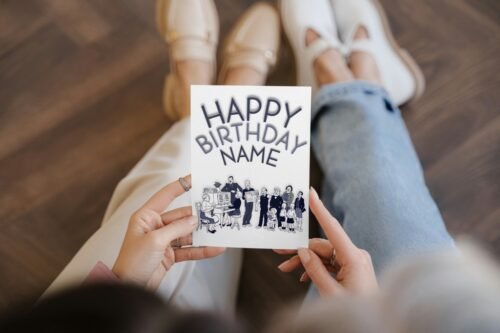 Hand holding personalised The Broons birthday card showing the full front design with family illustration and “Happy Birthday [Name]” text.