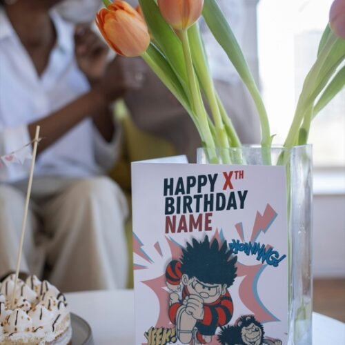 Comic-style personalised card showing Dennis and Gnasher jumping out with sound effects